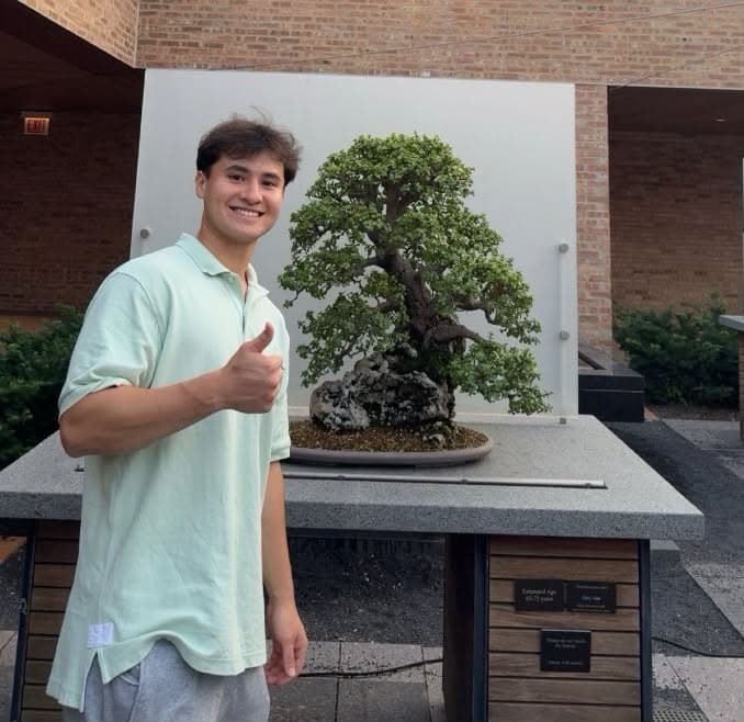 Quinn, the tutor behind QC Tutoring, standing beside a bonsai tree